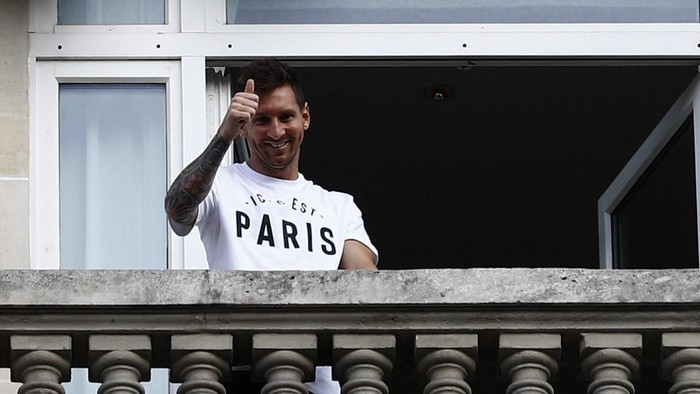 Argentinian football player Lionel Messi waves at fans from a balcony of the Royal Monceau hotel in Paris on August 10, 2021, as the football legend is expected to sign an initial two-year deal with Paris Saint-Germain football club following his departure from boyhood club Barcelona. (Photo by Sameer Al-DOUMY / AFP)