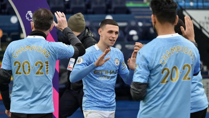MANCHESTER, ENGLAND - MAY 23: Phil Foden of Manchester City walks through a guard of honour before Manchester City are presented with the Premier League Trophy following the Premier League match between Manchester City and Everton at Etihad Stadium on May 23, 2021 in Manchester, England. A limited number of fans will be allowed into Premier League stadiums as Coronavirus restrictions begin to ease in the UK. (Photo by Peter Powell - Pool/Getty Images)