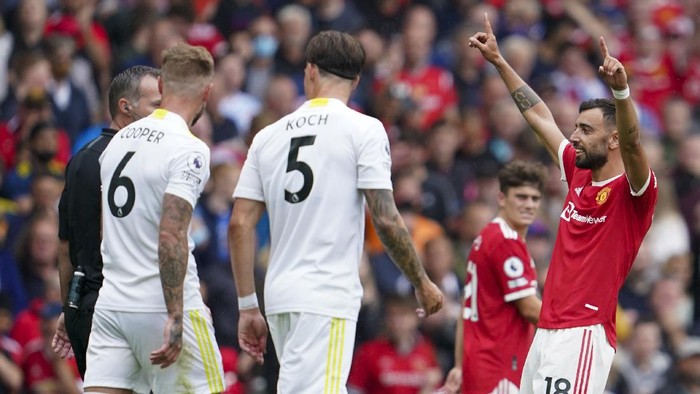 Manchester Uniteds Bruno Fernandes, right, celebrates after scoring his third goal during the English Premier League soccer match between Manchester United and Leeds United at Old Trafford in Manchester, England, Saturday, Aug. 14, 2021. (AP Photo/Jon Super)