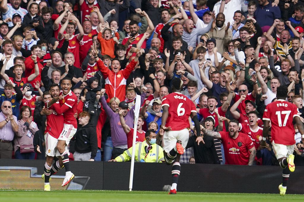Manchester United's Bruno Fernandes, left, celebrates with teammates after scoring his team's first goal during the English Premier League soccer match between Manchester United and Leeds United at Old Trafford in Manchester, England, Saturday, Aug. 14, 2021. (AP Photo/Jon Super)
