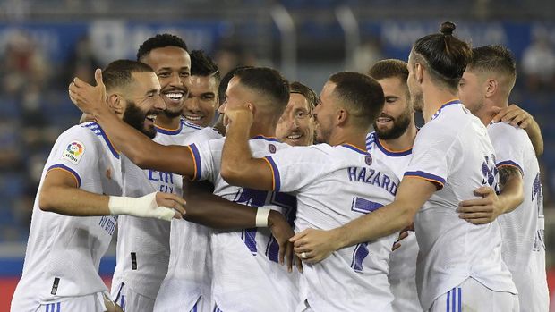 Real Madrid's Karim Benzema, left, celebrates with team mates after scoring his side's opening goal during a Spanish La Liga soccer match between Alaves and Real Madrid at the Mendizorroza stadium in Vitoria, Spain, Saturday, Aug. 14, 2021. (AP Photo/Alvaro Barrientos)