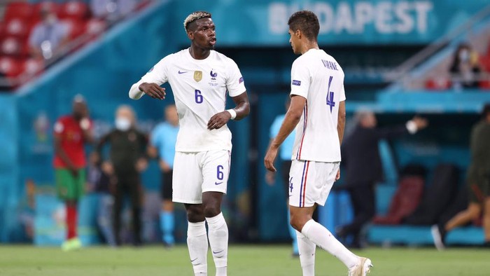 BUDAPEST, HUNGARY - JUNE 23: Paul Pogba of France talks with teammate Raphael Varane during the UEFA Euro 2020 Championship Group F match between Portugal and France at Puskas Arena on June 23, 2021 in Budapest, Hungary. (Photo by Alex Pantling/Getty Images)