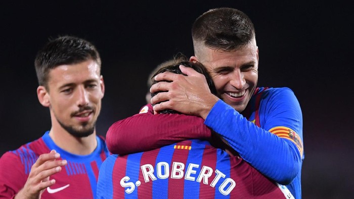 BARCELONA, SPAIN - AUGUST 15: Sergi Roberto of FC Barcelona  celebrates with Gerard Pique after scoring their teams fourth goal during the LaLiga Santander match between FC Barcelona and Real Sociedad at Camp Nou on August 15, 2021 in Barcelona, Spain. FC Barcelona will host between 20,000 and 22,0000 fans in the stadium as the Regional government has authorised a capacity of 30 percent with the requirement to maintain a meter and a half distance between people or groups of people who have tickets. (Photo by Alex Caparros/Getty Images)
