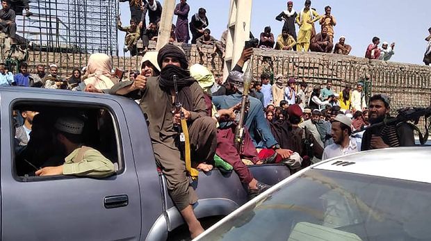 Taliban fighters sit on a vehicle along the street in Jalalabad province on August 15, 2021. (Photo by - / AFP)