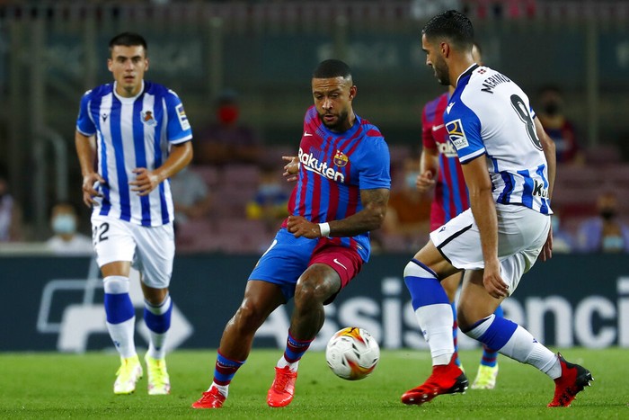 Real Sociedads Mikel Merino, right, vies for the ball with Barcelonas Memphis Depay during a Spanish La Liga soccer match between Barcelona and Real Sociedad at Camp Nou stadium in Barcelona, Spain, Sunday, Aug. 15, 2021. (AP Photo/Joan Monfort)