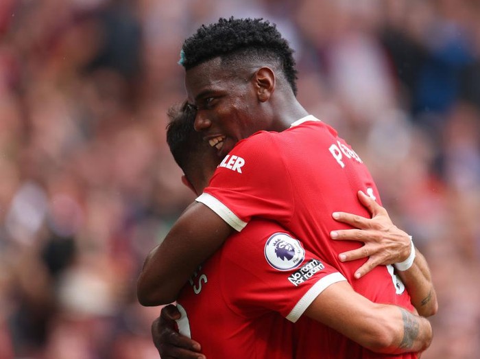 MANCHESTER, ENGLAND - AUGUST 14: Bruno Fernandes of Manchester United celebrates with teammate Paul Pogba after scoring their sides fourth goal and his hat-trick during the Premier League match between Manchester United  and  Leeds United at Old Trafford on August 14, 2021 in Manchester, England. (Photo by Catherine Ivill/Getty Images,)
