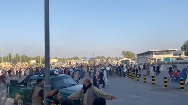 A horde of people run towards the Kabul Airport Terminal, after Taliban insurgents took control of the presidential palace in Kabul, August 16, 2021, in this still image taken from video obtained from social media. Jawad Sukhanyar/via REUTERS THIS IMAGE HAS BEEN SUPPLIED BY A THIRD PARTY. MANDATORY CREDIT. NO RESALES. NO ARCHIVES.