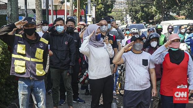 Warga Kota Bandung bersama petugas gabungan menghentikan aktivitas saat momentum peringatan detik-detik proklamasi kemerdekaan Republik Indonesia di kawasan Simpang Lima Asia Afrika, Selasa (17/8). (CNNIndonesia.com/Huyogo Simbolon)