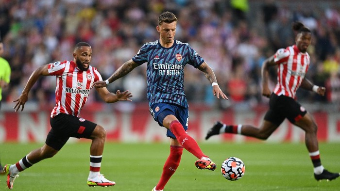 BRENTFORD, ENGLAND - AUGUST 13: Ben White of Arsenal controls the ball under pressure from Bryan Mbeumo of Brentford during the Premier League match between Brentford and Arsenal at Brentford Community Stadium on August 13, 2021 in Brentford, England. (Photo by Shaun Botterill/Getty Images)