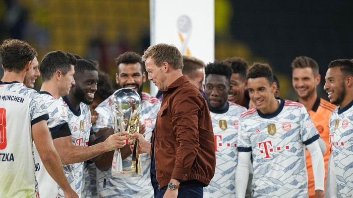 Bayerns head coach Julian Nagelsmann holds the trophy as he celebrates with players after winning the German Supercup soccer match between Borussia Dortmund and Bayern Munich in Dortmund, Germany, Tuesday, Aug. 17, 2021. (AP Photo/Martin Meissner)