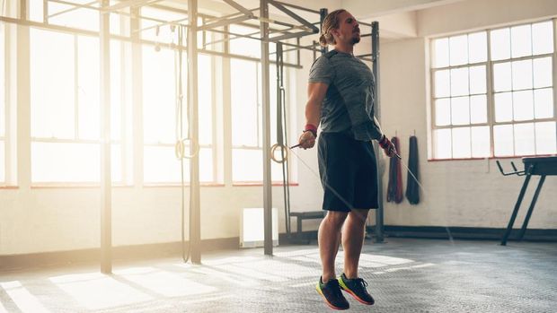 Shot of a muscular young man training with a skipping rope at the gym