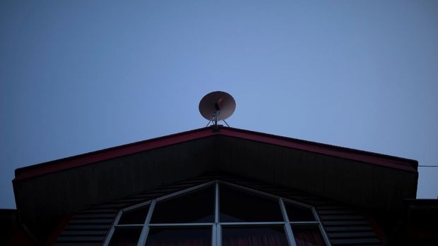 The Starlink antenna is seen on the roof of the John F Kennedy School located in the village of Sotomo, outside the town of Cochamo, Los Lagos region, Chile, August 7, 2021. Picture taken August 7, 2021. Sotomo is one of two places in Chile to be chosen for a pilot project run by billionaire Elon Musk to receive free internet for a year. The signal is received via a satellite dish installed on the school's roof, which transmits through a Wi-Fi device. REUTERS/Pablo Sanhueza         SEARCH 