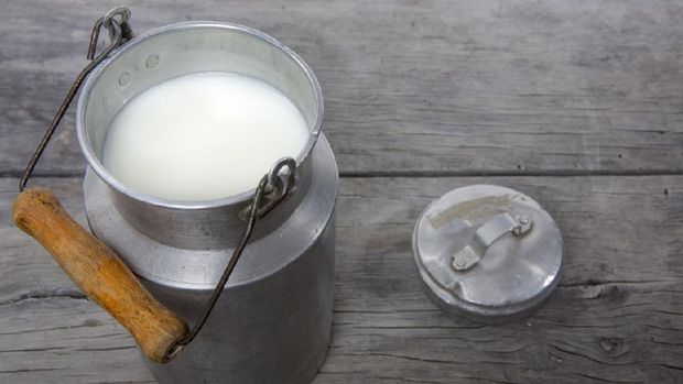 Traditional milk canister on old wood