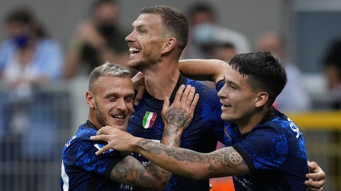 Inter Milans Edin Dzeko, center, celebrates with his teammates Federico Dimarco, left, and Martin Satriano after scoring his sides fourth goal during the Serie A soccer match between Inter Milan and Genoa, at the San Siro stadium in Milan, Italy, Saturday, Aug. 21, 2021. (AP Photo/Antonio Calanni)
