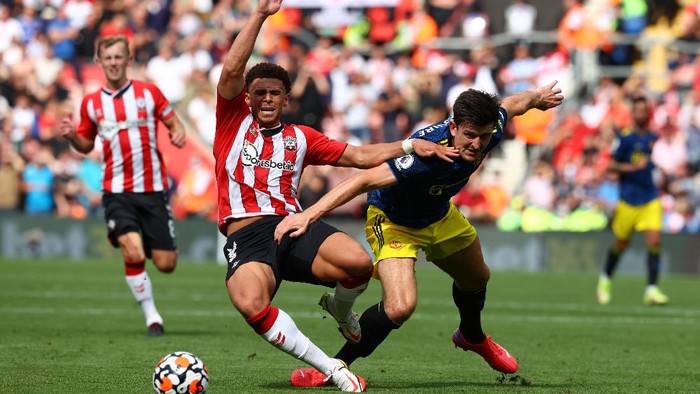SOUTHAMPTON, ENGLAND - AUGUST 22: Che Adams of Southampton is fouled by Harry Maguire of Manchester United during the Premier League match between Southampton and Manchester United at St Marys Stadium on August 22, 2021 in Southampton, England. (Photo by Michael Steele/Getty Images)