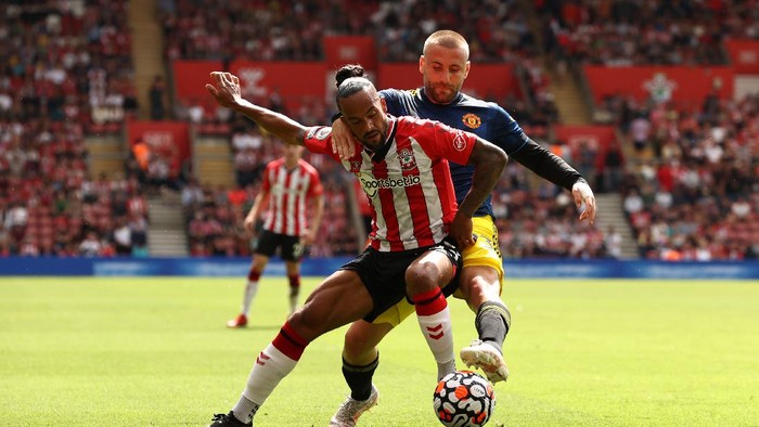 SOUTHAMPTON, ENGLAND - AUGUST 22: Theo Walcott of Southampton holds off Luke Shaw of Manchester United during the Premier League match between Southampton and Manchester United at St Marys Stadium on August 22, 2021 in Southampton, England. (Photo by Ryan Pierse/Getty Images)