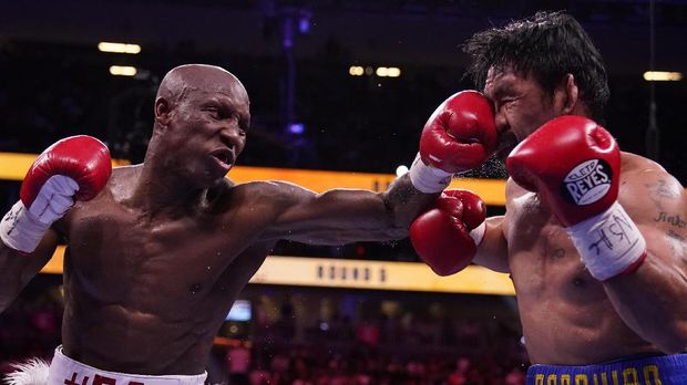 Yordenis Ugas, left, of Cuba, hits Manny Pacquiao, of the Philippines, in a welterweight championship boxing match Saturday, Aug. 21, 2021, in Las Vegas. (AP Photo/John Locher)