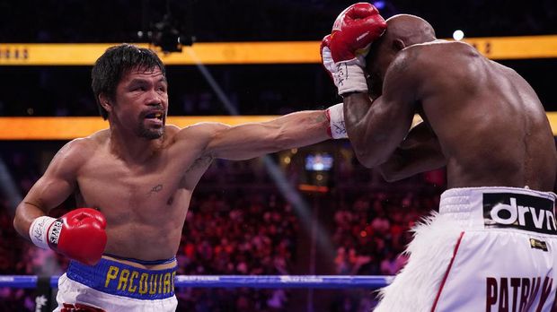 Manny Pacquiao, left, of the Philippines, hits Yordenis Ugas, of Cuba, in a welterweight championship boxing match Saturday, Aug. 21, 2021, in Las Vegas. (AP Photo/John Locher)