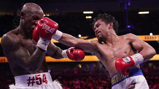 Manny Pacquiao, right, of the Philippines, hits Yordenis Ugas, of Cuba, in a welterweight championship boxing match Saturday, Aug. 21, 2021, in Las Vegas. (AP Photo/John Locher)