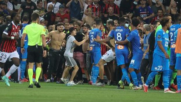 Fans invade the pitch during the French L1 football match between OGC Nice and Olympique de Marseille (OM) at the Allianz Riviera stadium in Nice, southern France on August 22, 2021. - The French Ligue 1 game between Nice and Marseille was halted on August 22, 2021, when fans of the home side invaded the pitch and angrily confronted opposing player Dimitri Payet. An AFP journalist at the game said trouble flared in the 75th minute when Marseille star Payet, who had been targeted by plastic bottles every time he took a corner, lobbed one back into the stands. (Photo by Valery HACHE / AFP)