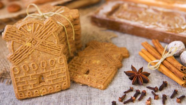 camilan speculoos Traditional Dutch 'speculaas' (spiced shortcrust cookies). With authentic wooden cookie cutters especially made for these cookies in the background.