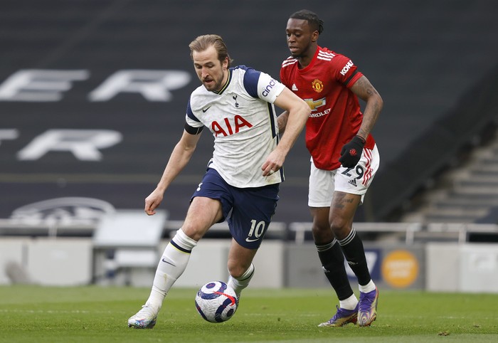 LONDON, ENGLAND - APRIL 11: Harry Kane of Tottenham Hotspur runs with the ball whilst under pressure from Aaron Wan-Bissaka of Manchester United during the Premier League match between Tottenham Hotspur and Manchester United at Tottenham Hotspur Stadium on April 11, 2021 in London, England. Sporting stadiums around the UK remain under strict restrictions due to the Coronavirus Pandemic as Government social distancing laws prohibit fans inside venues resulting in games being played behind closed doors. (Photo by Adrian Dennis - Pool/Getty Images)