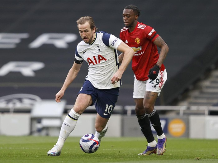 LONDON, ENGLAND - APRIL 11: Harry Kane of Tottenham Hotspur runs with the ball whilst under pressure from Aaron Wan-Bissaka of Manchester United during the Premier League match between Tottenham Hotspur and Manchester United at Tottenham Hotspur Stadium on April 11, 2021 in London, England. Sporting stadiums around the UK remain under strict restrictions due to the Coronavirus Pandemic as Government social distancing laws prohibit fans inside venues resulting in games being played behind closed doors. (Photo by Adrian Dennis - Pool/Getty Images)