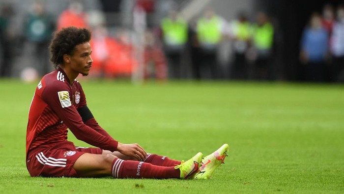 Bayern Munichs German midfielder Leroy Sane sits on the pitch during the German first division Bundesliga football match FC Bayern Munich v FC Cologne in Munich, southern Germany, on August 22, 2021. (Photo by Christof STACHE / AFP) / DFL REGULATIONS PROHIBIT ANY USE OF PHOTOGRAPHS AS IMAGE SEQUENCES AND/OR QUASI-VIDEO