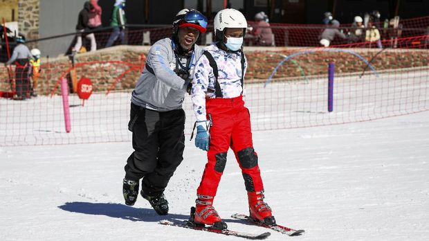 Hope Ramokotjo teaches a young skier during a ski lesson at Kapoko Snow Park at Afriski Mountain Resort in Butha Buthe, Lesotho, July 31, 2021. Picture taken July 31, 2021. REUTERS/Sumaya Hisham