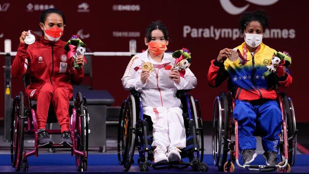 TOKYO, JAPAN - AUGUST 26: Silver medalist Ni Nengah Widiasih of Team Indonesia, Gold medalist Guo Lingling, and Bronze medalist Clara Fuentes of Team Venezuela pose for a photo after the women's -41kg powerlifting final on day 2 of the Tokyo 2020 Paralympic Games at on August 26, 2021 in Tokyo, Japan. (Photo by Christopher Jue/Getty Images for International Paralympic Committee)