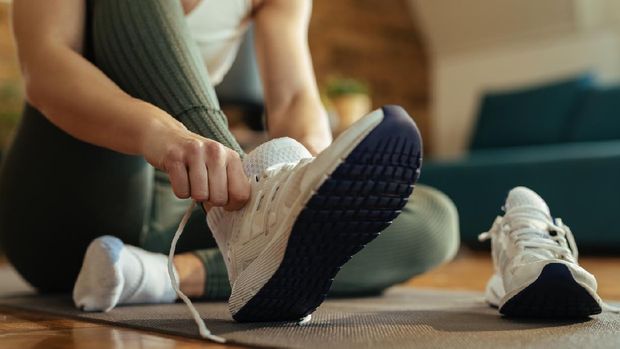 Close-up of sportswoman putting on sneakers.