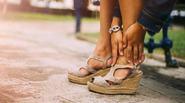A young woman with feet pain from gih heels