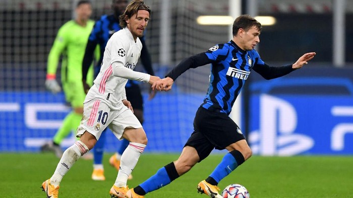 MILAN, ITALY - NOVEMBER 25: Nicolo Barella of Inter Milan is challenged by Luka Modric of Real Madrid during the UEFA Champions League Group B stage match between FC Internazionale and Real Madrid at Stadio Giuseppe Meazza on November 25, 2020 in Milan, Italy. Football Stadiums around Europe remain empty due to the Coronavirus Pandemic as Government social distancing laws prohibit fans inside venues resulting in fixtures being played behind closed doors. (Photo by Valerio Pennicino/Getty Images)