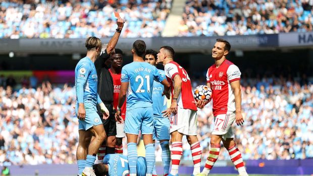 MANCHESTER, ENGLAND - AUGUST 28: Referee Martin Atkinson awards Granit Xhaka of Arsenal a red card during the Premier League match between Manchester City and Arsenal at Etihad Stadium on August 28, 2021 in Manchester, England. (Photo by Catherine Ivill/Getty Images)