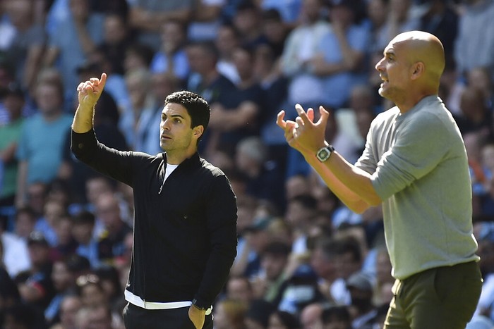 Arsenals manager Mikel Arteta, left, and Manchester Citys head coach Pep Guardiola gesture during the English Premier League soccer match between Manchester City and Arsenal at Etihad stadium in Manchester, England, Saturday, Aug. 28, 2021. (AP Photo/Rui Vieira)