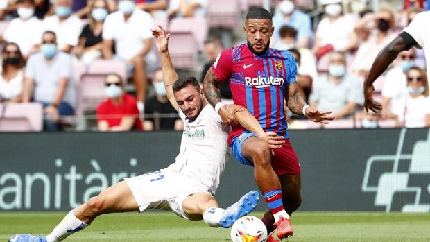 Getafe's Juan Iglesias, left, challenges Barcelona's Memphis Depay during the Spanish La Liga soccer match between Barcelona and Getafe, at the Camp Nou stadium in Barcelona, Spain, Sunday, Aug. 29, 2021. (AP Photo/Joan Monfort)