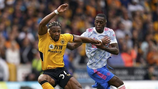 Wolverhampton Wanderers' Adama Traore, left, and Manchester United's Aaron Wan-Bissaka battle for the ball during the English Premier League soccer match between Wolverhampton Wanderers and Manchester United at Molineux Stadium, Wolverhampton, England, Sunday, Aug. 29, 2021. (Nick Potts/PA via AP)