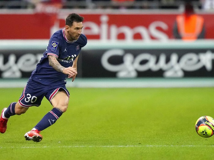 Reims' Marshall Munetsi, left, challenges for the ball with PSG's Lionel Messi during the France League One soccer match between Reims and Paris Saint-Germain, at the Stade Auguste-Delaune in Reims, France, Sunday, Aug. 29, 2021. (AP Photo/Francois Mori)
