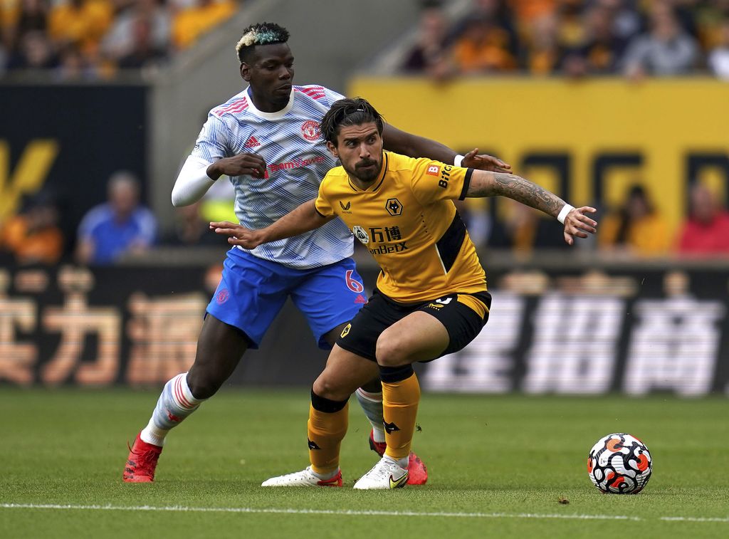 Manchester United's Paul Pogba, left, and Wolverhampton Wanderers' Ruben Neves battle for the ball during the English Premier League soccer match between Wolverhampton Wanderers and Manchester United at Molineux Stadium, Wolverhampton, England, Sunday, Aug. 29, 2021. (Nick Potts/PA via AP)