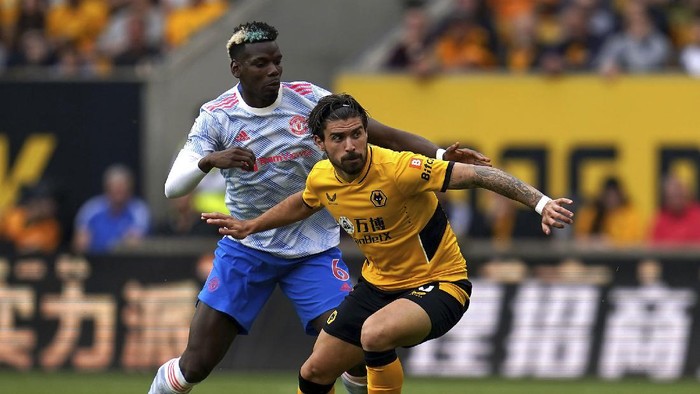 Manchester Uniteds Paul Pogba, left, and Wolverhampton Wanderers Ruben Neves battle for the ball during the English Premier League soccer match between Wolverhampton Wanderers and Manchester United at Molineux Stadium, Wolverhampton, England, Sunday, Aug. 29, 2021. (Nick Potts/PA via AP)