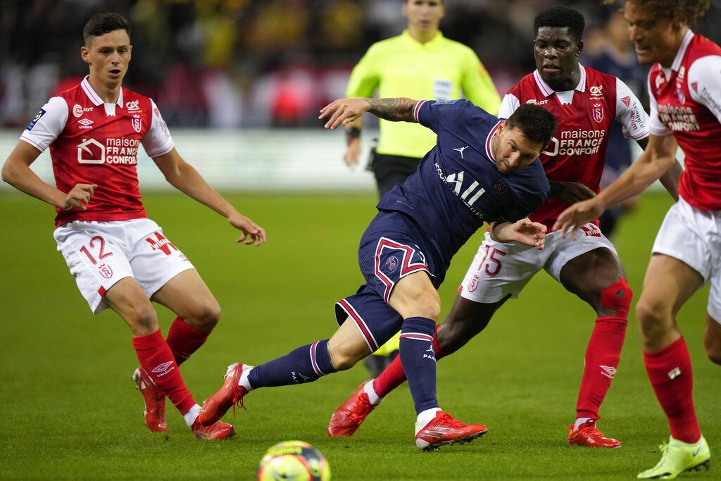 PSG's Lionel Messi, centre, challenges for the ball with Reims' Alexis Flips, left, and Reims' Marshall Munetsi during the France League One soccer match between Reims and Paris Saint-Germain, at the Stade Auguste-Delaune in Reims, France, Sunday, Aug. 29, 2021. (AP Photo/Francois Mori)