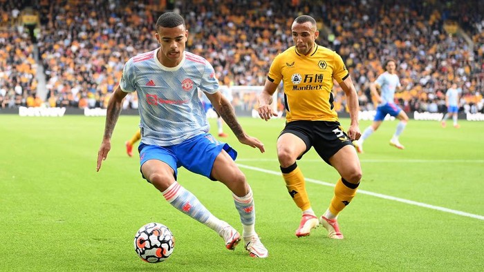 WOLVERHAMPTON, ENGLAND - AUGUST 29: Mason Greenwood of Manchester United battles for possession with Romain Saiss of Wolverhampton Wanderers  during the Premier League match between Wolverhampton Wanderers  and  Manchester United at Molineux on August 29, 2021 in Wolverhampton, England. (Photo by Michael Regan/Getty Images)