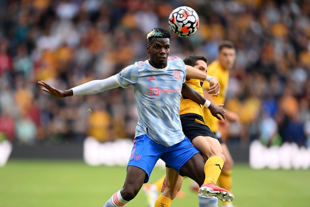 WOLVERHAMPTON, ENGLAND - AUGUST 29: Paul Pogba of Manchester United battles for possession with Joao Moutinho of Wolverhampton Wanderers  during the Premier League match between Wolverhampton Wanderers  and  Manchester United at Molineux on August 29, 2021 in Wolverhampton, England. (Photo by Michael Regan/Getty Images)