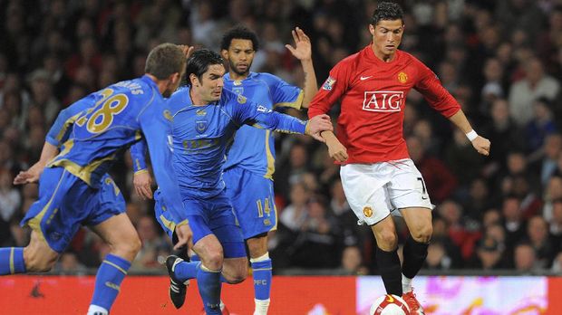 Manchester United's Portuguese midfielder Cristiano Ronaldo (R) vies with Portsmouth's English midfielder Sean Davis (L) Portsmouth's Scottish midfielder Richard Hughes (2L) and Portsmouth's English forward Jermain Pennant during the English Premiership football match at Old Trafford, Manchester, north-west England, on April 22, 2009. AFP PHOTO/ANDREW YATES.  FOR EDITORIAL USE ONLY Additional licence required for any commercial/promotional use or use on TV or internet (except identical online version of newspaper) of Premier League/Football League photos. Tel DataCo +44 207 2981656. Do not alter/modify photo. (Photo by ANDREW YATES / AFP)
