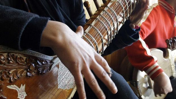 FILE - In this Jan. 7, 2013 file photo, an Afghan girl practices playing the sitar in a class at the Afghan National Institute of Music, ANIM, in Kabul, Afghanistan. A few years after the Taliban were ousted in 2001, and with Afghanistan still in ruins, Ahmad Sarmast left his home in Melborne, Australia where he had sought asylum in the 90s, on a mission: to revive music in the country of his birth. The music school Sarmast founded was a unique experiment in inclusivity for the war-ravaged nation — with orphans and street kids in the student body.  (AP Photo/Musadeq Sadeq, File)