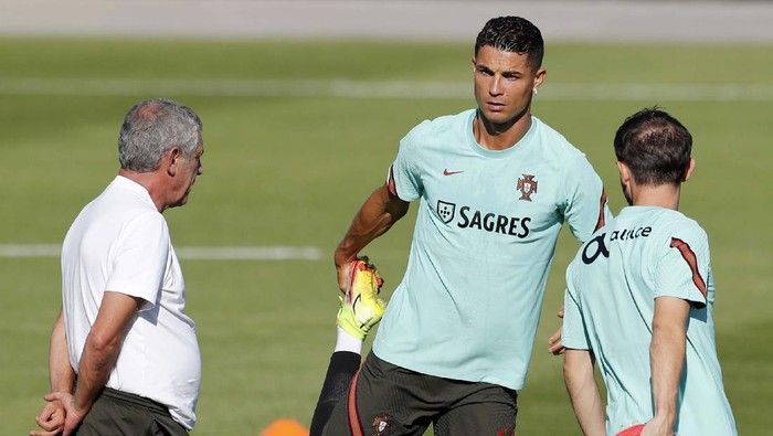 Resmi ke MU, Ronaldo Masih Fokus ke Timnas Portugal Portugal's Cristiano Ronaldo looks at coach Fernando Santos while stretching during a training session in Oeiras, outside Lisbon, Monday, Aug. 30, 2021. Portugal will play Ireland on Wednesday in a Qatar 2022 World Cup qualifying match. (AP Photo/Armando Franca)