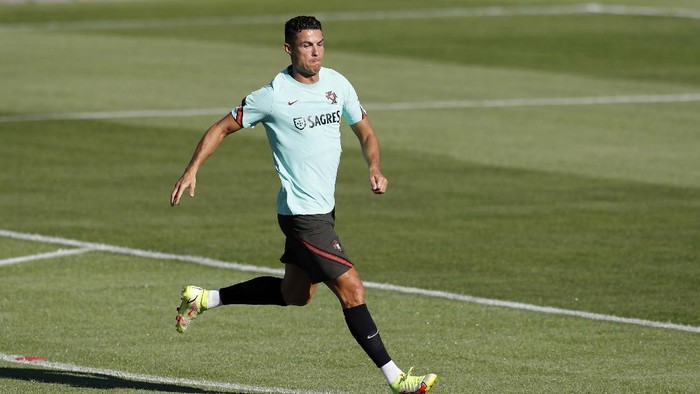 Resmi ke MU, Ronaldo Masih Fokus ke Timnas Portugal Portugal's Cristiano Ronaldo looks at coach Fernando Santos while stretching during a training session in Oeiras, outside Lisbon, Monday, Aug. 30, 2021. Portugal will play Ireland on Wednesday in a Qatar 2022 World Cup qualifying match. (AP Photo/Armando Franca)