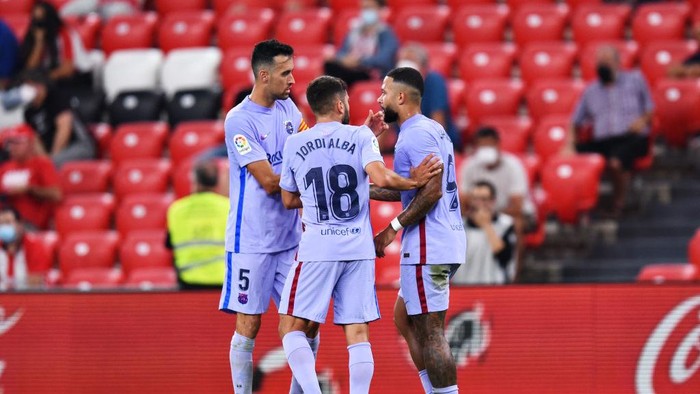BILBAO, SPAIN - AUGUST 21: Memphis Depay of FC Barcelona celebrates with teammates Jordi Alba and Sergio Busquets after scoring his sides first goal during the LaLiga Santander match between Athletic Club and FC Barcelona at San Mames Stadium on August 21, 2021 in Bilbao, Spain. (Photo by Juan Manuel Serrano Arce/Getty Images)