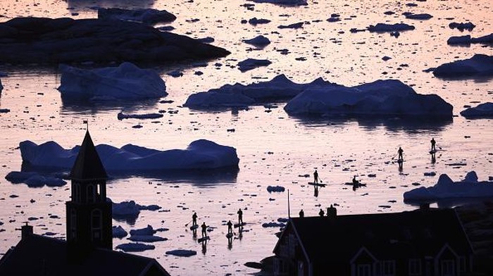 ILULISSAT, GREENLAND - SEPTEMBER 02: A pedestrian walks as ice and icebergs float in Disko Bay on September 02, 2021 in Ilulissat, Greenland. Greenland in 2021 is experiencing one of its biggest ice-melt years in recorded history. Scientists studying the Greenland Ice Sheet observed rainfall on the highest point in Greenland for the first time ever this August. Researchers from Denmark estimated that in July of this year enough ice melted on the Greenland Ice Sheet to cover the entire state of Florida with two inches of water. The observations come on the heels of the recent United Nations report on global warming which stated that accelerating climate change is driving an increase in extreme weather events. (Photo by Mario Tama/Getty Images)