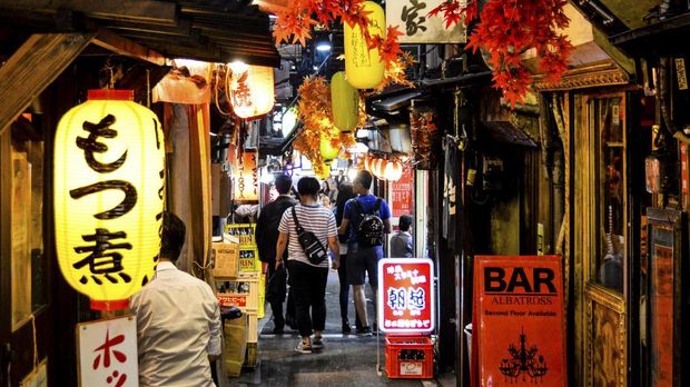 People in the streets of Omoide-Yokocho in Shinjuku Tokyo Japan. This is one of the few areas in the city that are still intact from the development that started in the 60's till today. Surrounded by skyscrapers and close to Shinjuku station this small alley is packed with small restaurants.